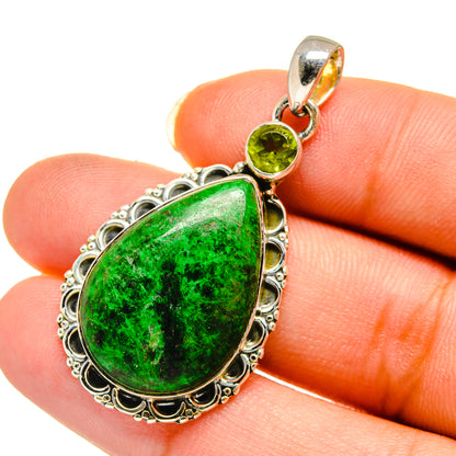 Sterling silver peridot pendant on finger, green teardrop stone with ornate frame