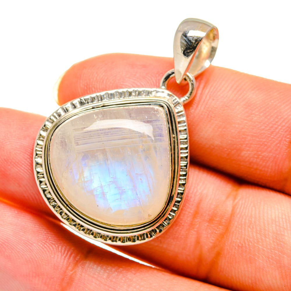 Oval rainbow moonstone pendant close-up with silver bail and textured bezel