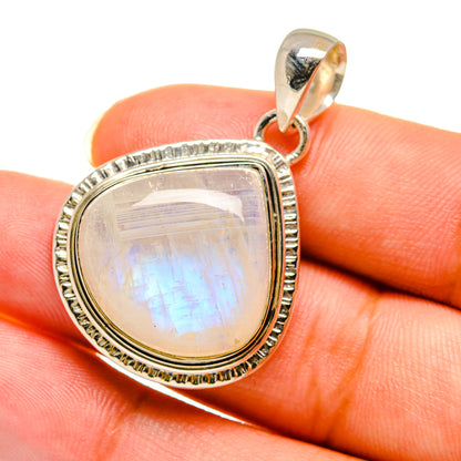 Oval rainbow moonstone pendant close-up with silver bail and textured bezel