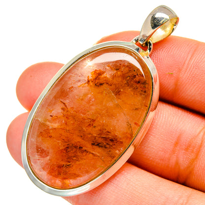 Sterling silver strawberry quartz pendant close-up with oval amber-orange cabochon stone