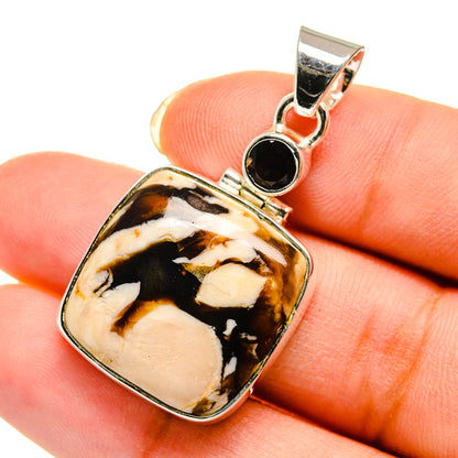 Sterling silver pendant with mottled amber, black, and cream stone and dark accent