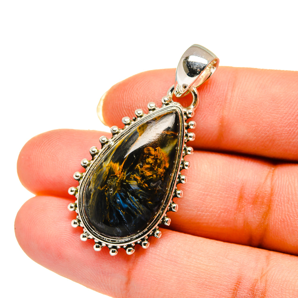 Sterling silver pietersite teardrop pendant held on fingertip, bead-edge bezel