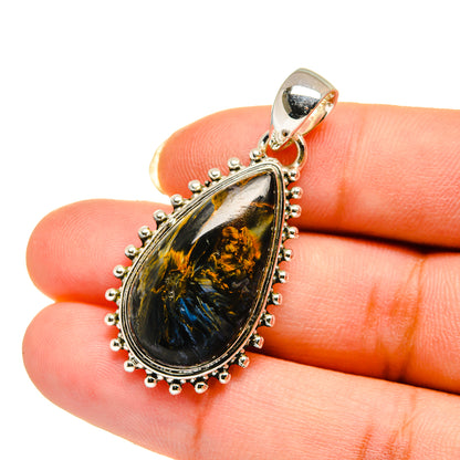 Sterling silver pietersite teardrop pendant held on fingertip, bead-edge bezel