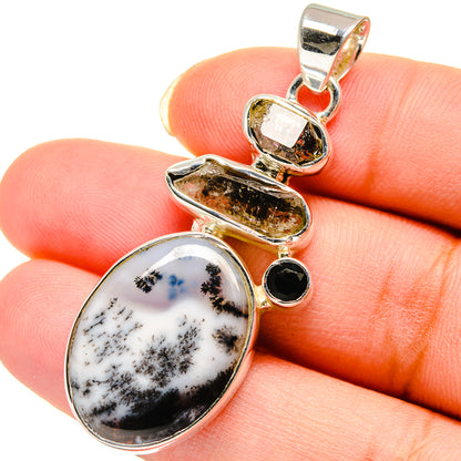 Sterling silver pendant with oval white dendritic opal and round black onyx in gold-toned bezel