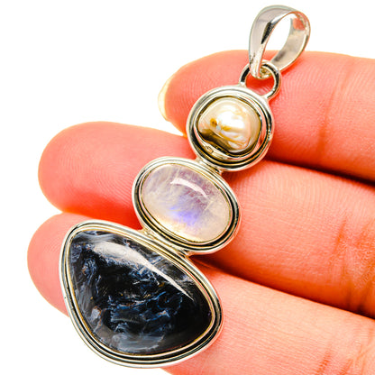 Sterling silver pendant with mother-of-pearl, iridescent stone, and dark oval gemstone