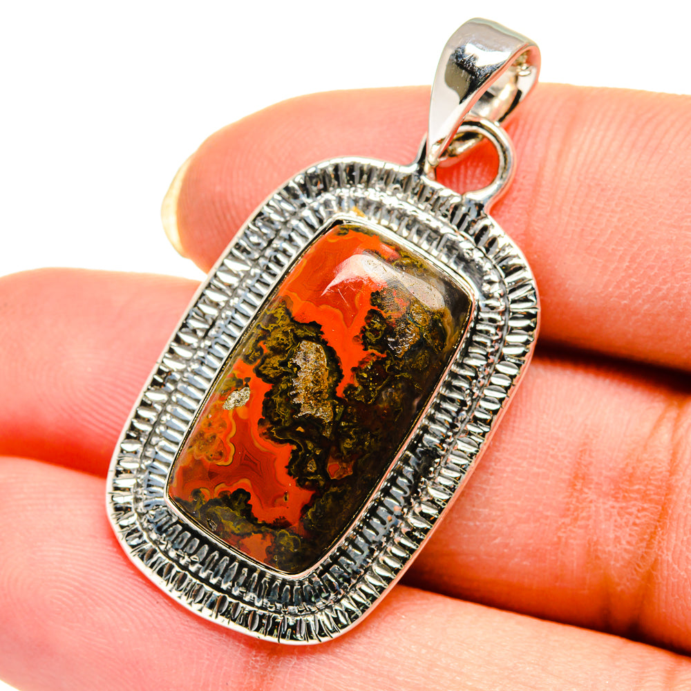 Oval agate pendant close-up: silver beaded bezel over orange and green marbled stone