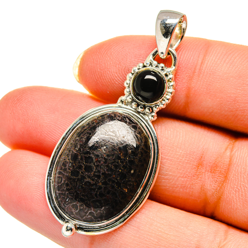 Sterling silver pendant with oval fossilized stone and round black onyx accent