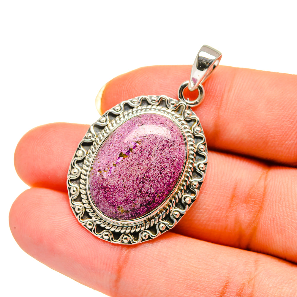 Stichtite pendant held in fingers, oval purple-pink stone in ornate 925 silver frame