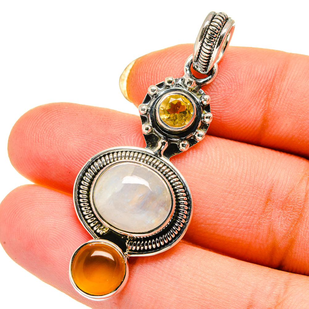 Sterling silver pendant with white and yellow cabochon stones and orange accents
