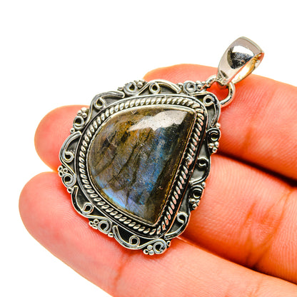 Sterling silver labradorite pendant with teardrop cabochon and ornate bezel, on bale