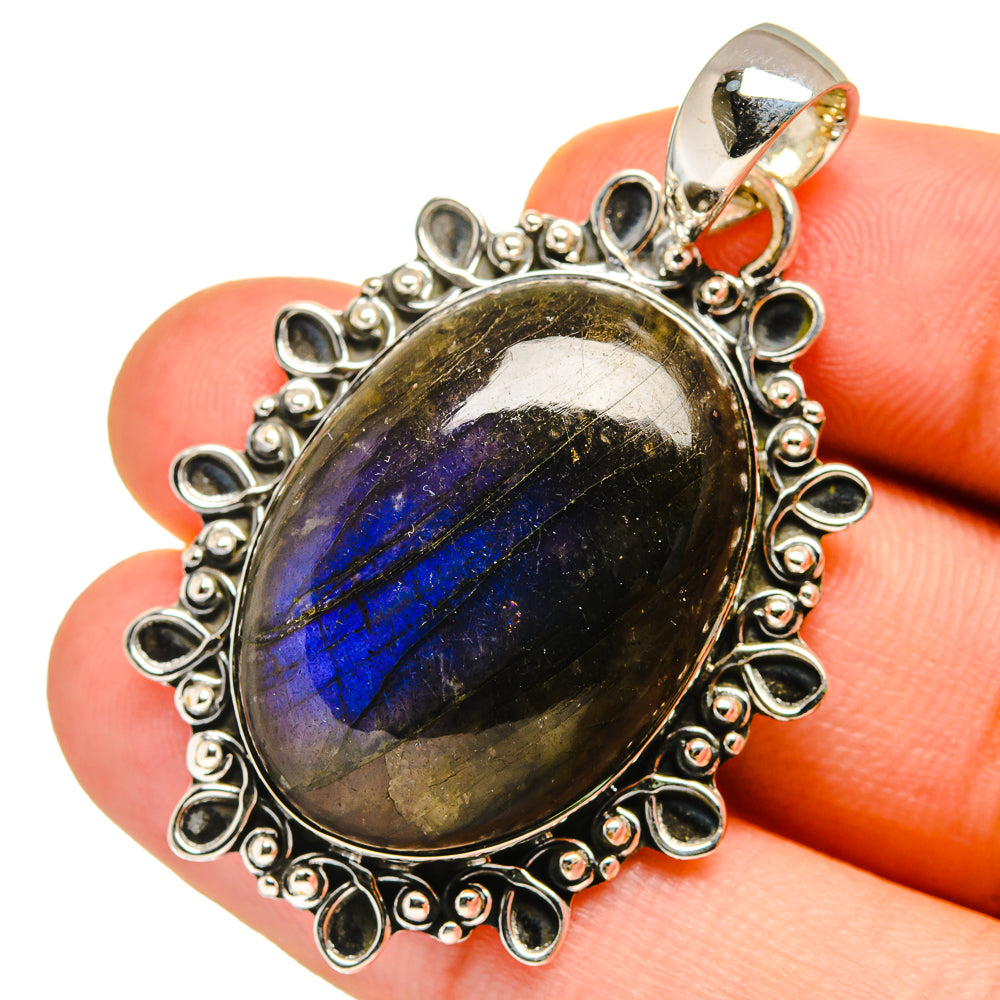 Labradorite pendant with oval cabochon bezel and ornate silver halo, bail loop