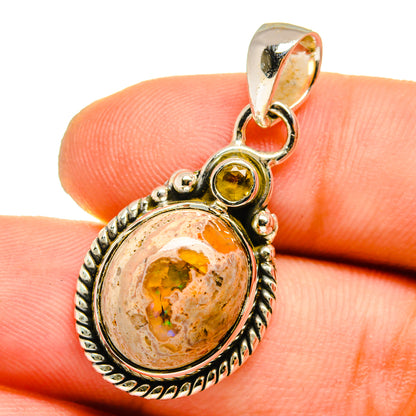 Sterling silver bezel-set oval pendant, orange fire opal surrounded by textured frame