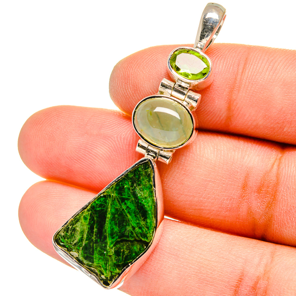 Sterling silver pendant close-up with green round and teardrop stones on the bail.