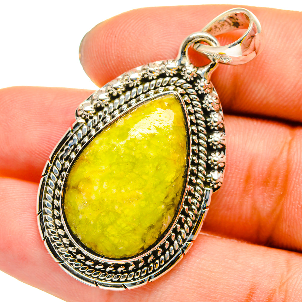 Sterling silver teardrop opal pendant with yellow-green cabochon stone, detailed frame