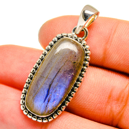 Oval labradorite pendant in sterling silver bezel with bead border, showing blue iridescence
