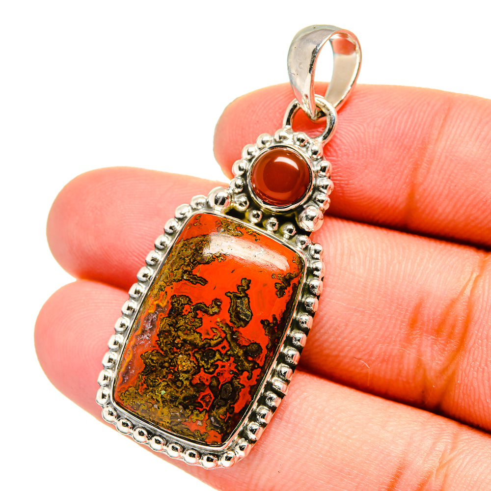 Sterling silver pendant close-up with rectangular red-and-green stone and round red cabochon