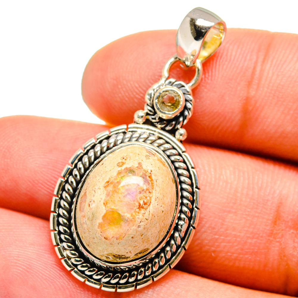 Sterling silver oval pendant with orange cabochon and textured rope-edge frame