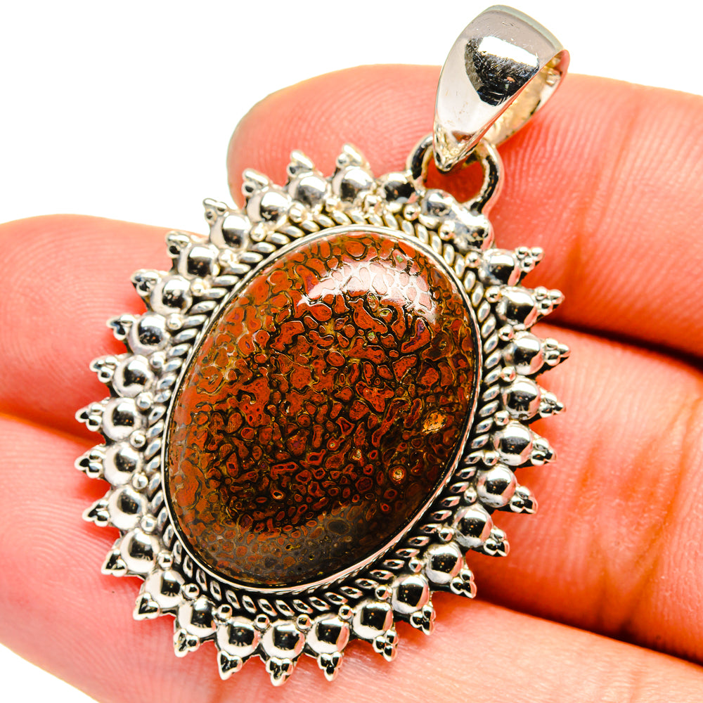 Oval amber-brown cabochon pendant with ornate silver spiked border and bail