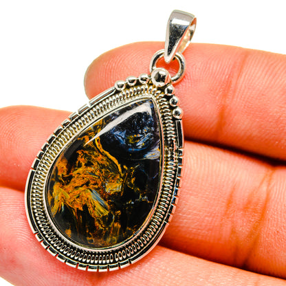 Pietersite teardrop pendant with blue-black and gold veined stone in silver frame