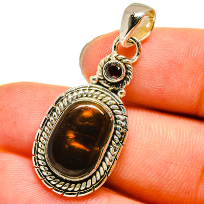 Fire agate oval pendant with small round dark stone, detailed sterling silver bail