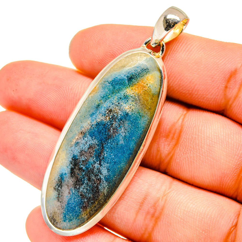 Oval gemstone pendant close-up with blue-green crystal stone in silver bezel