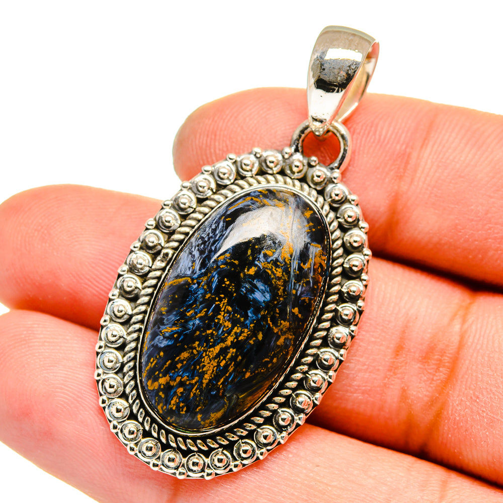 Sterling silver oval pietersite pendant on hand, blue-gold stone with bead border