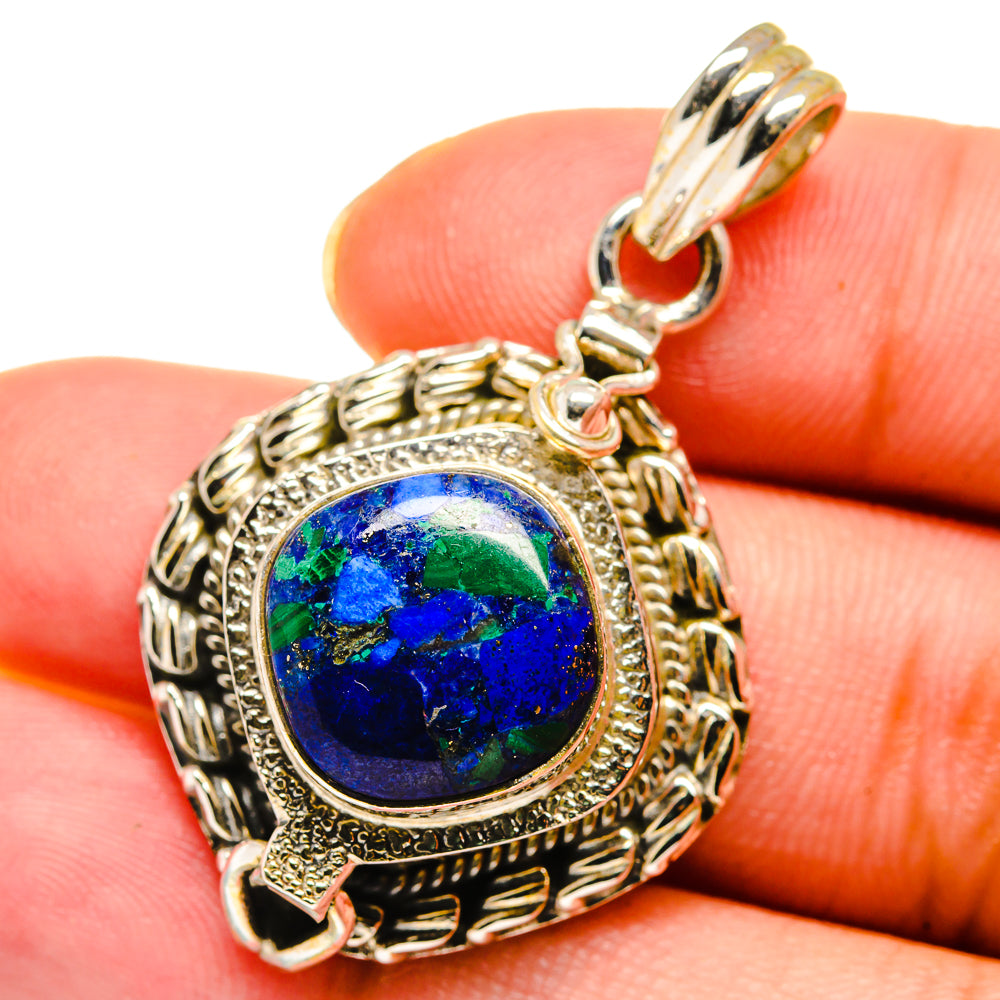 Round blue stone pendant with ornate rope border and hinged top bail, silver