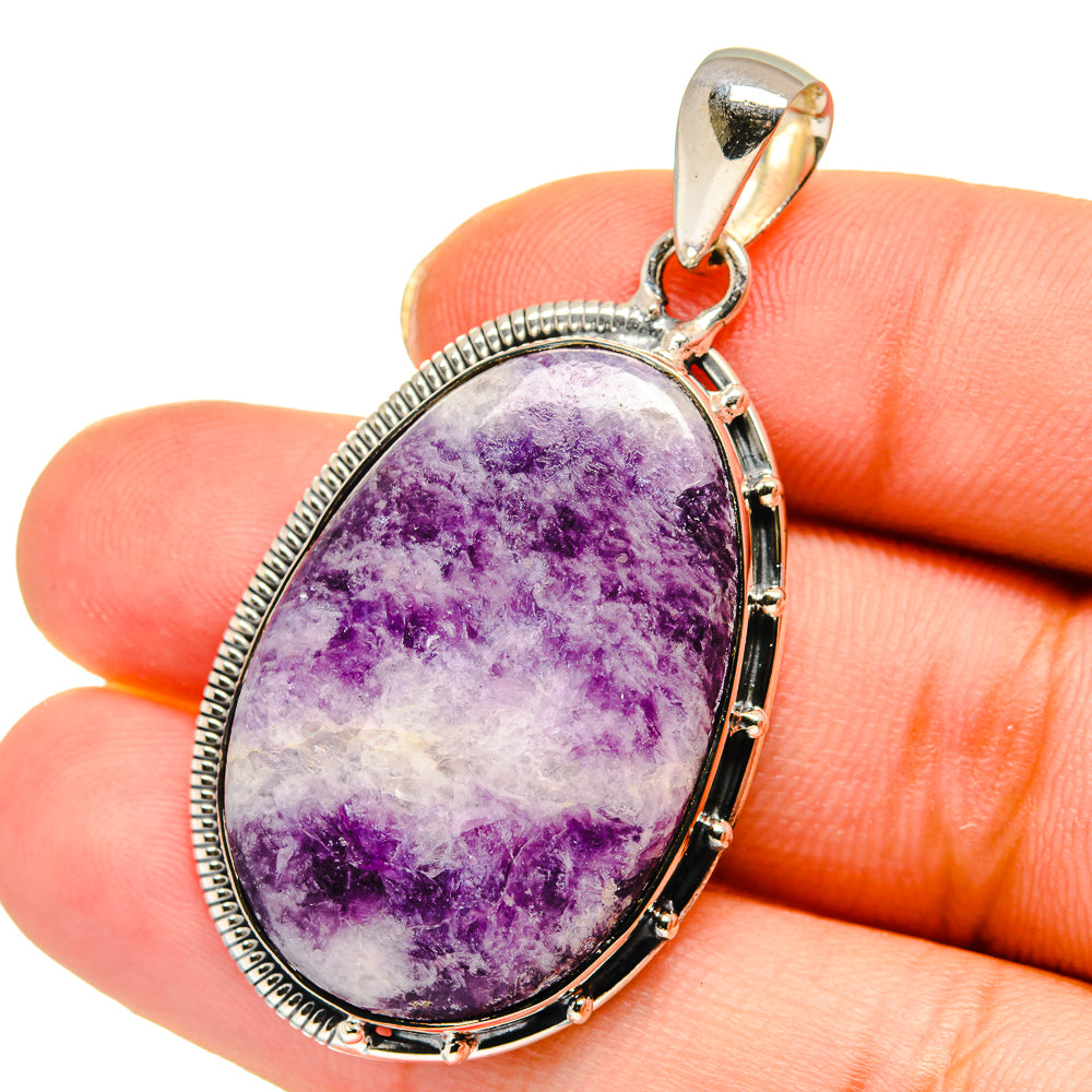 Oval charoite pendant in sterling silver setting, purple stone with speckled pattern.