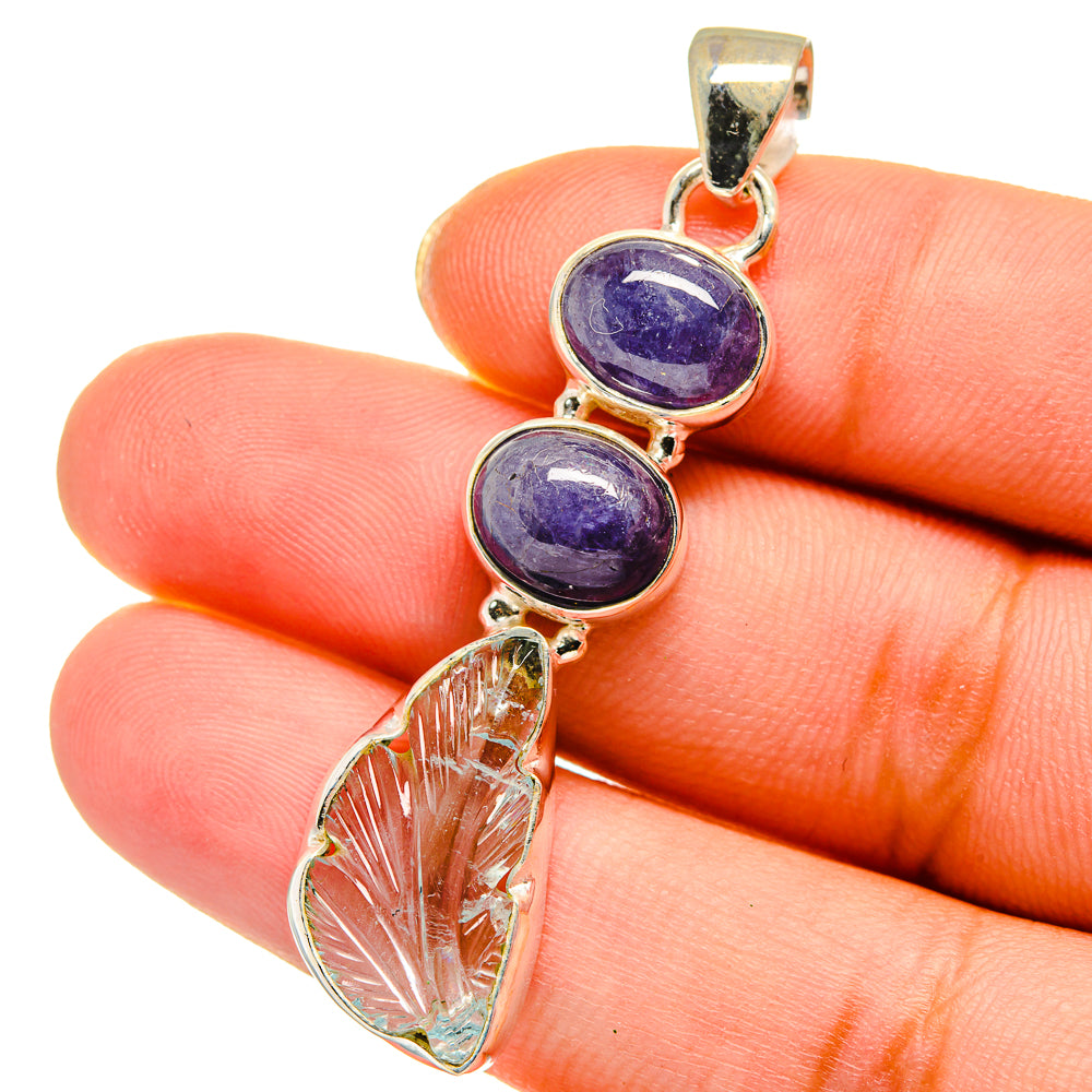 Gold-tone sterling silver pendant closeup with two blue-purple round stones and leaf