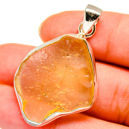 Amber glass pendant with sterling silver bezel and loop bail, faceted teardrop shape