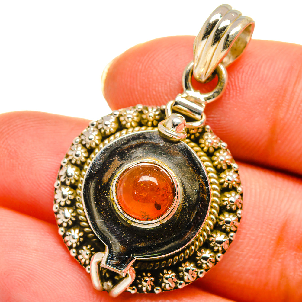 Round orange carnelian cabochon poison pendant, gold bezel with top bail detail
