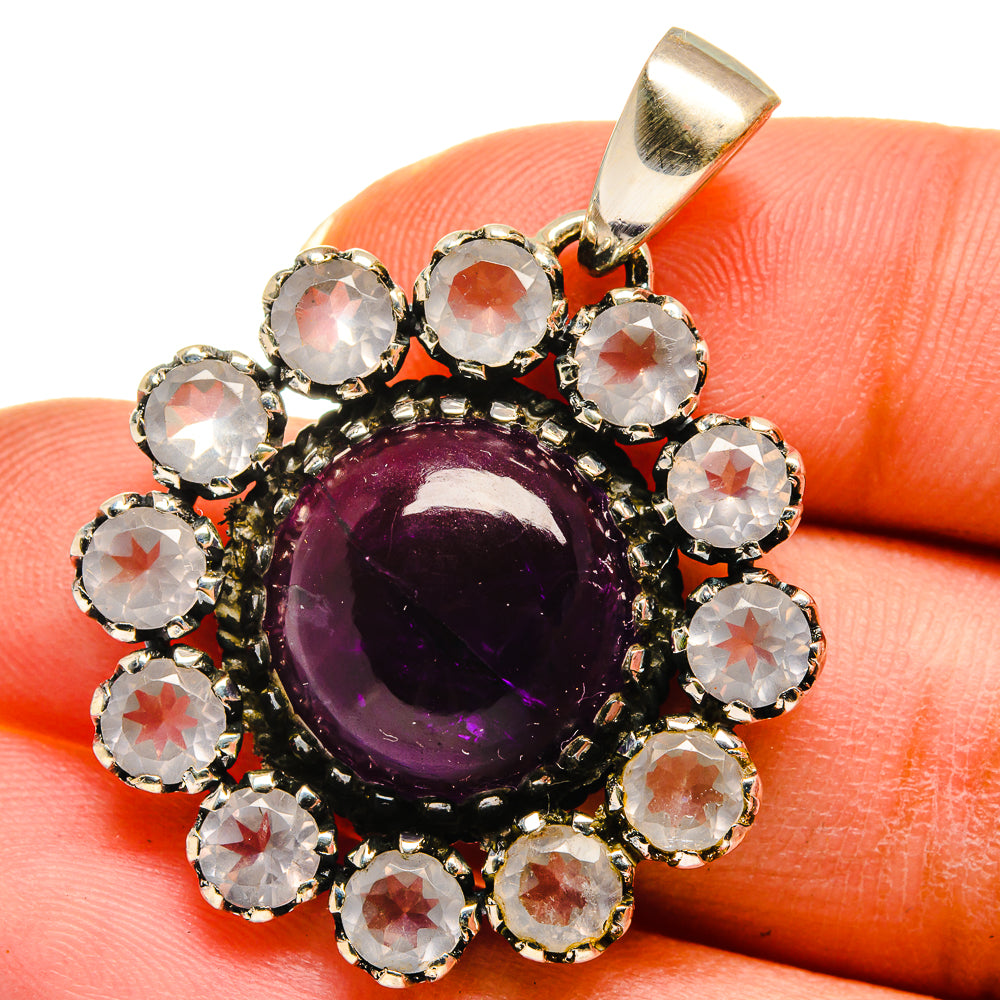 Purple amethyst cabochon pendant, surrounded by clear round crystals in silver bail