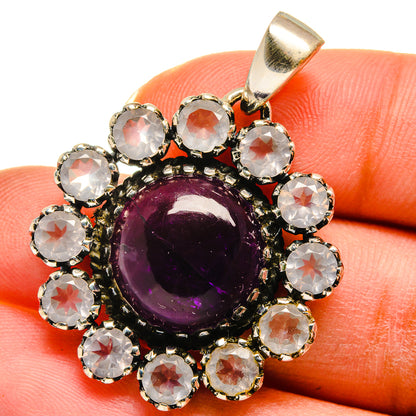Purple amethyst cabochon pendant, surrounded by clear round crystals in silver bail
