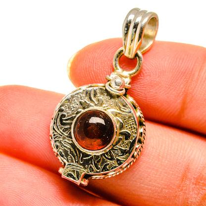 Close-up garnet poison pendant, 925 sterling silver, round dark red stone setting