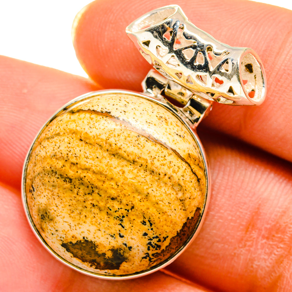 Round jasper pendant with amber speckled stone in silver bezel, bail visible