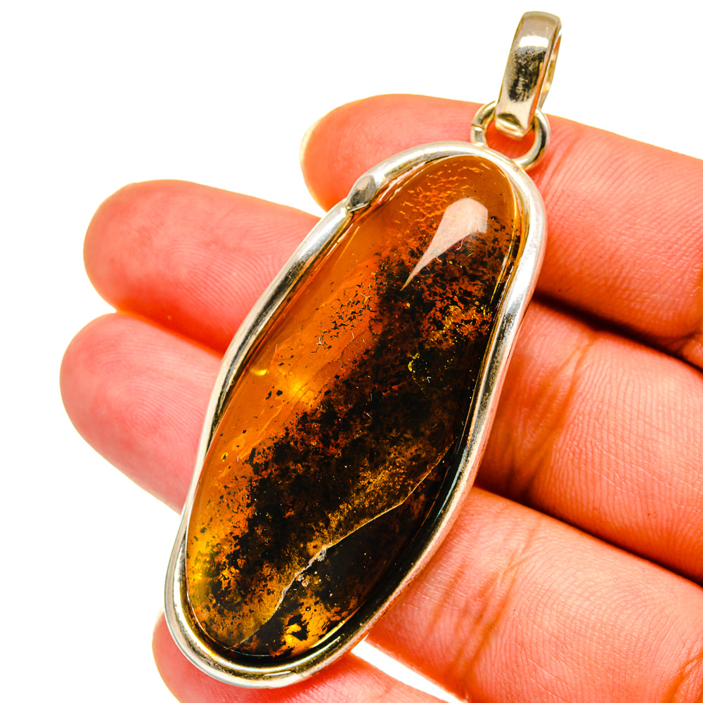 Oval amber pendant with gold-tone bail and oval 925 sterling silver frame