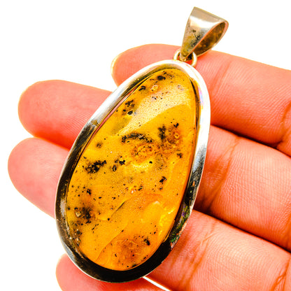 Amber teardrop pendant in silver bezel with textured yellow-gold stone, top bail