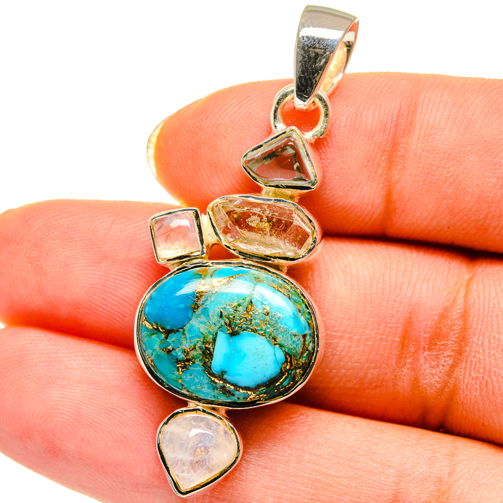 Turquoise cabochon pendant with dangling heart and triangular accents in silver tone.