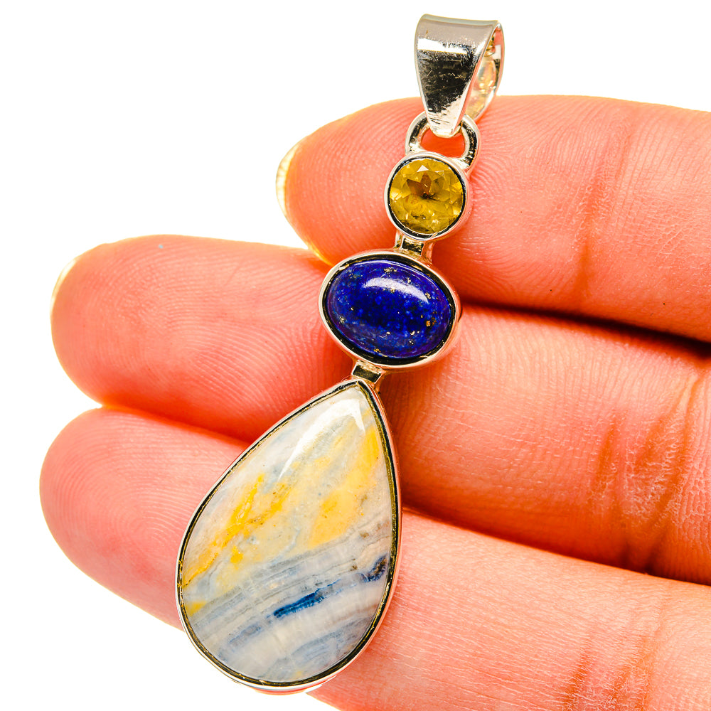 Sterling silver gemstone pendant close-up with lapis blue, yellow, and banded teardrop stone