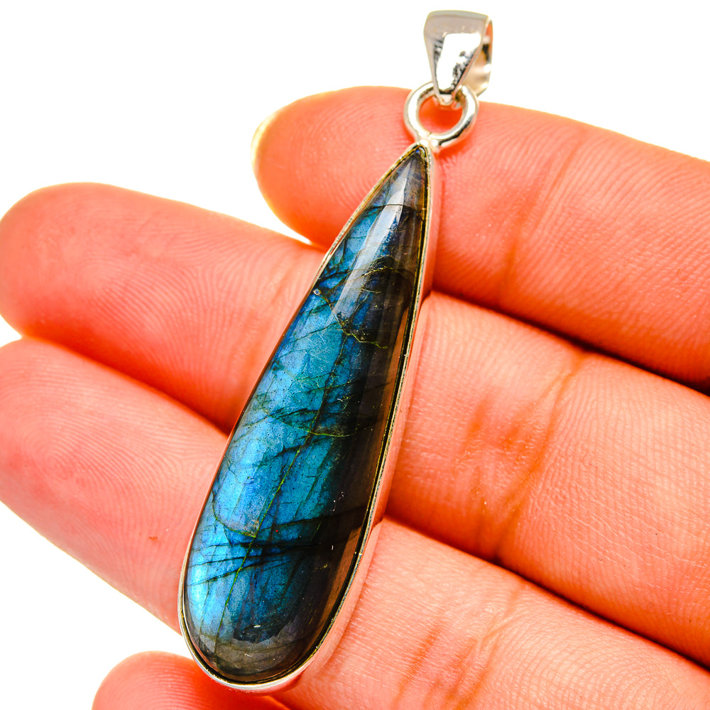 Labradorite teardrop pendant close-up on blue-black flash, with 925 sterling silver frame
