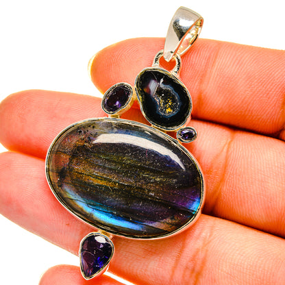 Oval iridescent pendant with blue sheen and gold highlights, framed by small purple accents.