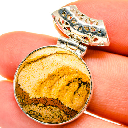 Round picture jasper pendant with silver bezel and ornate bail; yellow-brown stone.