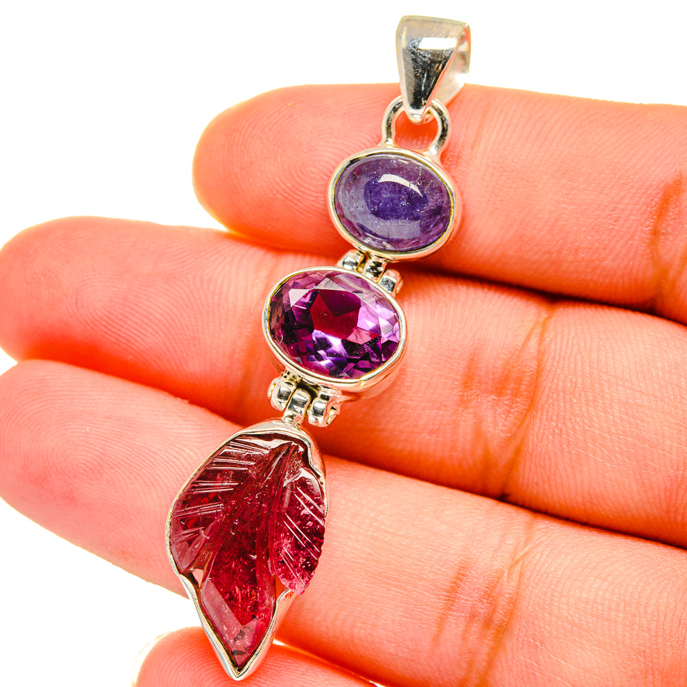 925 sterling silver pendant on finger with purple stones and red leaf-shaped gemstone