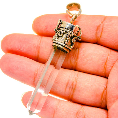 Quartz crystal pendant in silver-tone setting with gold bail, white stone tip