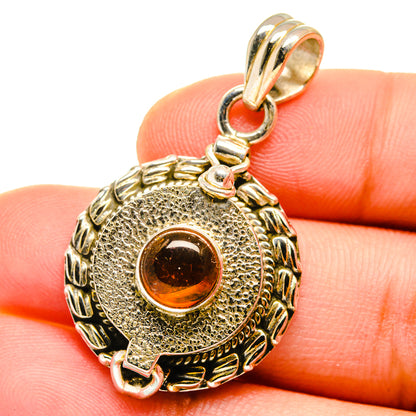 Round amber cabochon sterling silver pendant with ornate engraved frame and bail