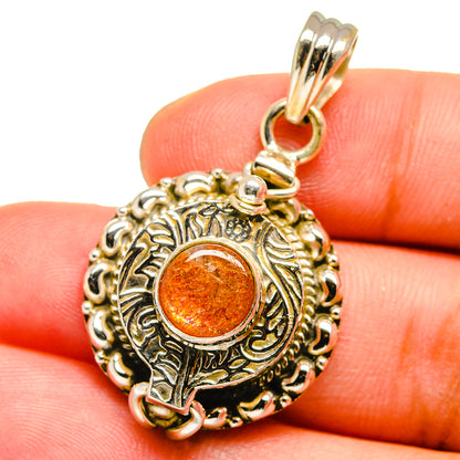 Sterling silver pendant with round orange stone and detailed filigree bezel