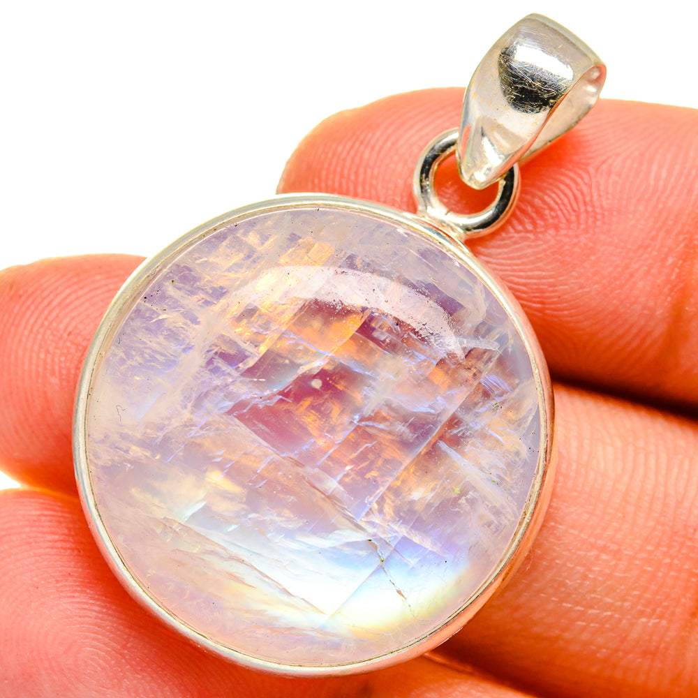 Round opalescent moonstone pendant in sterling silver bezel, showing iridescent purple-blue
