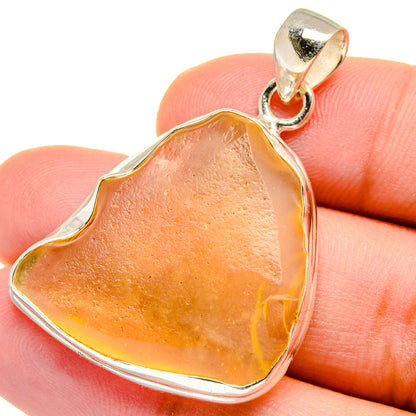 Heart-shaped amber glass pendant in sterling silver bezel with bail cap