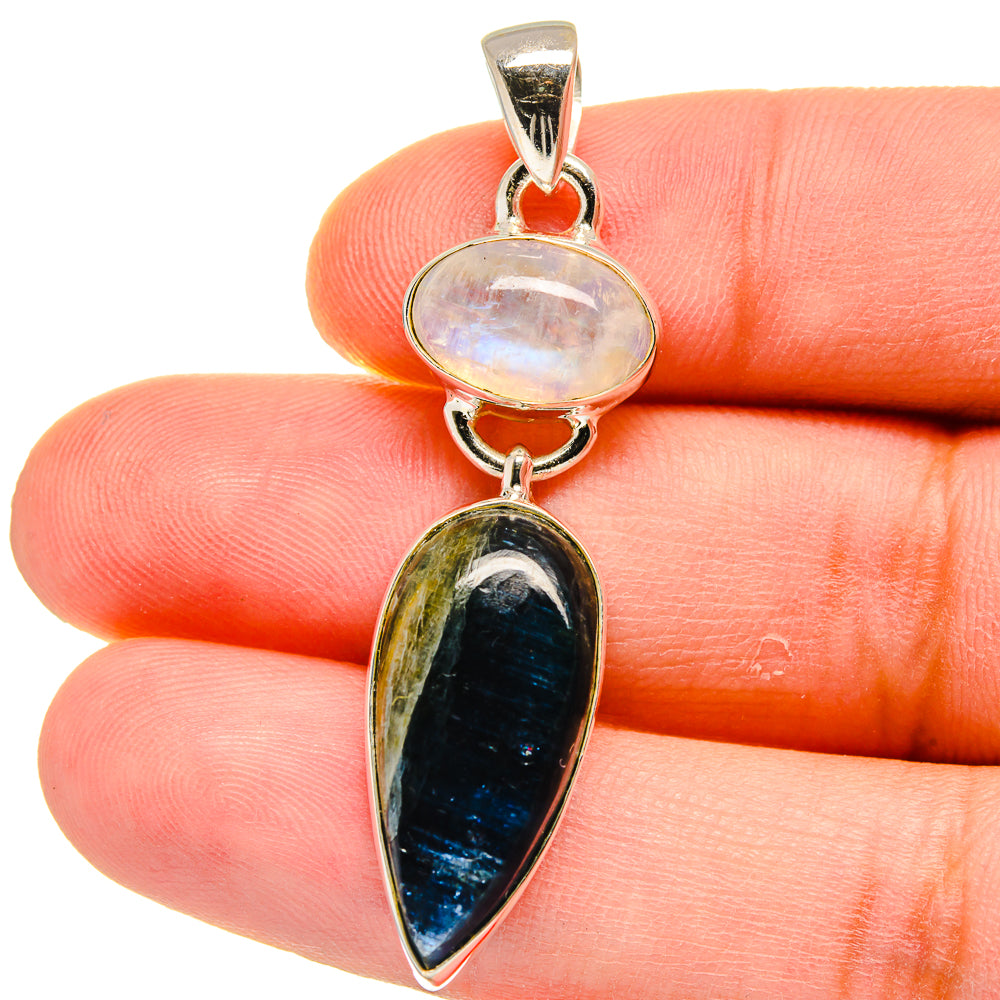 Sterling silver pendant with oval moonstone and blue kyanite, close-up on finger