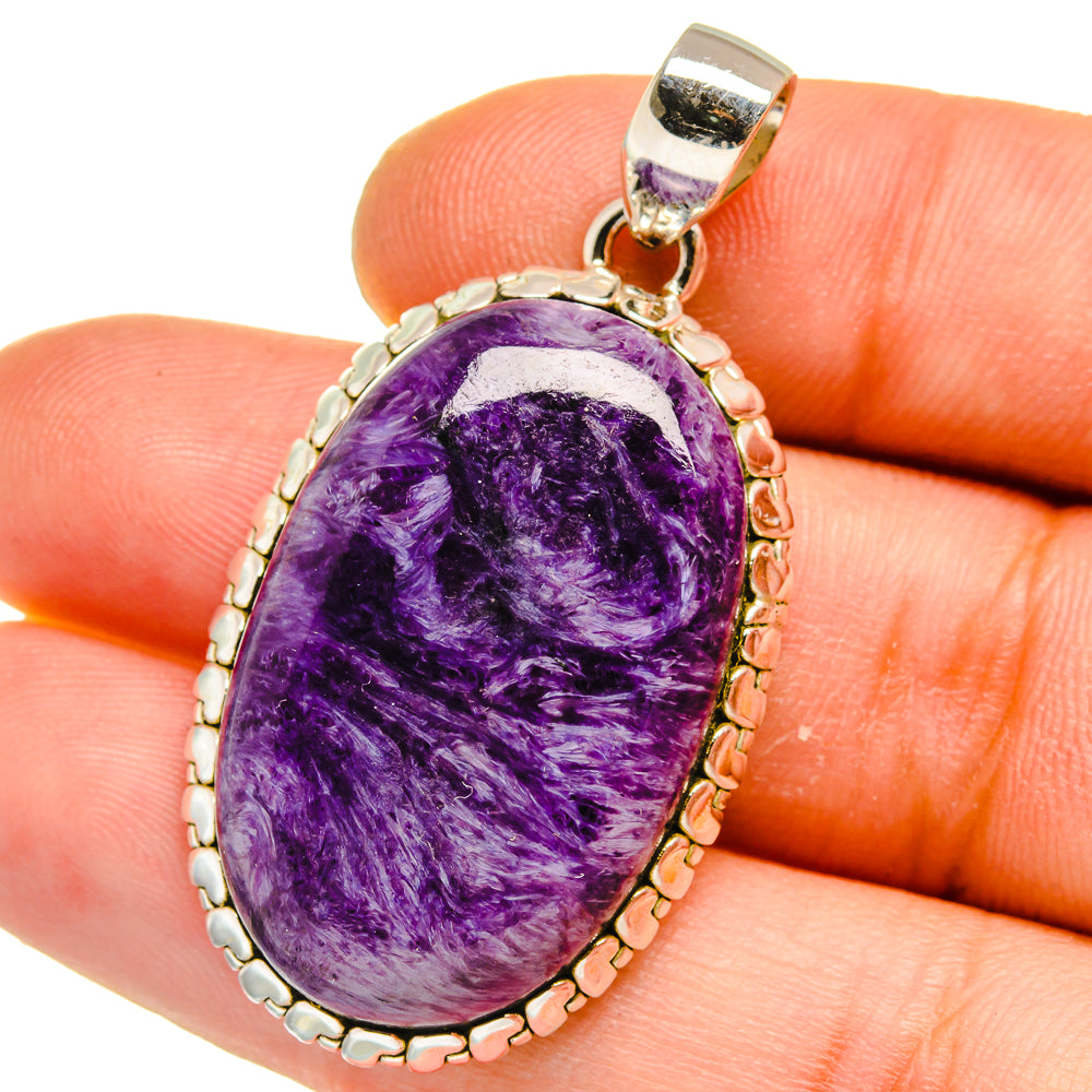 Oval purple charoite pendant on silver bail, beaded bezel with textured side.